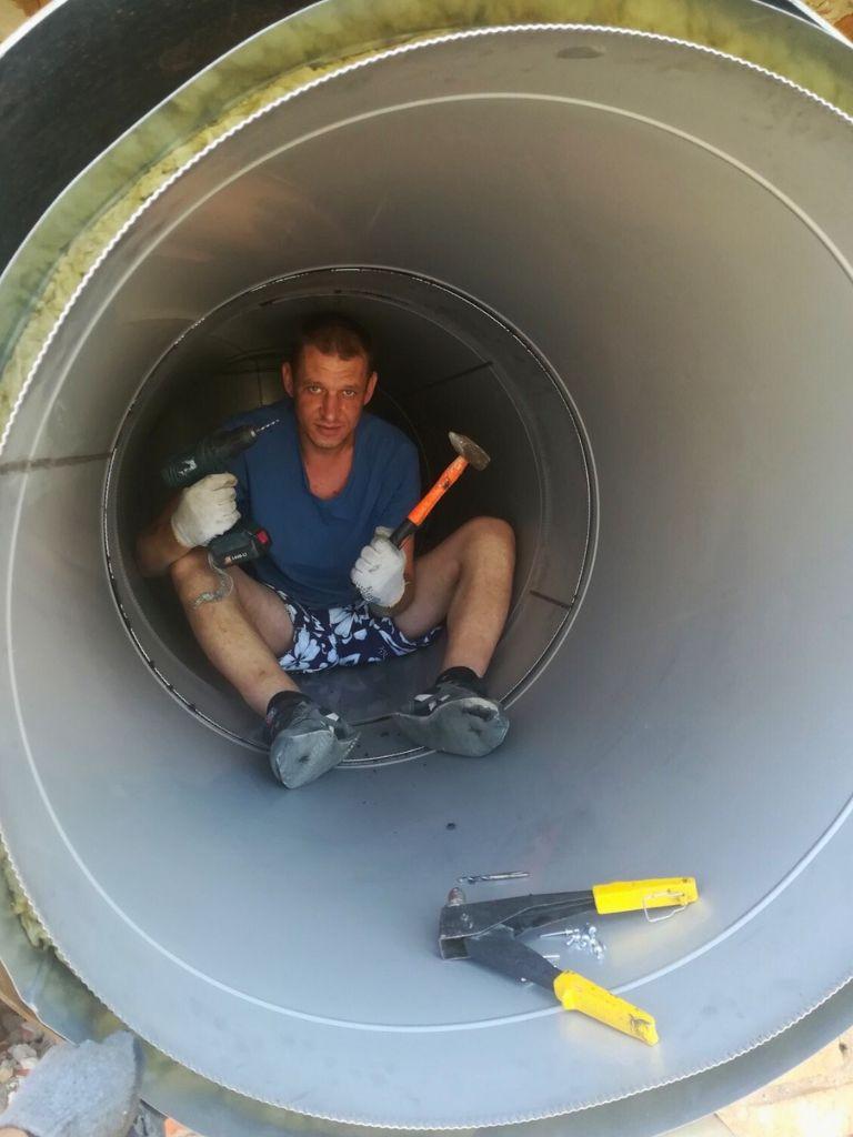 Installer working in shorts inside the gas duct system