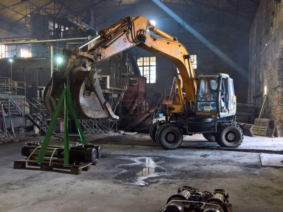 Excavator assisting in equipment installation