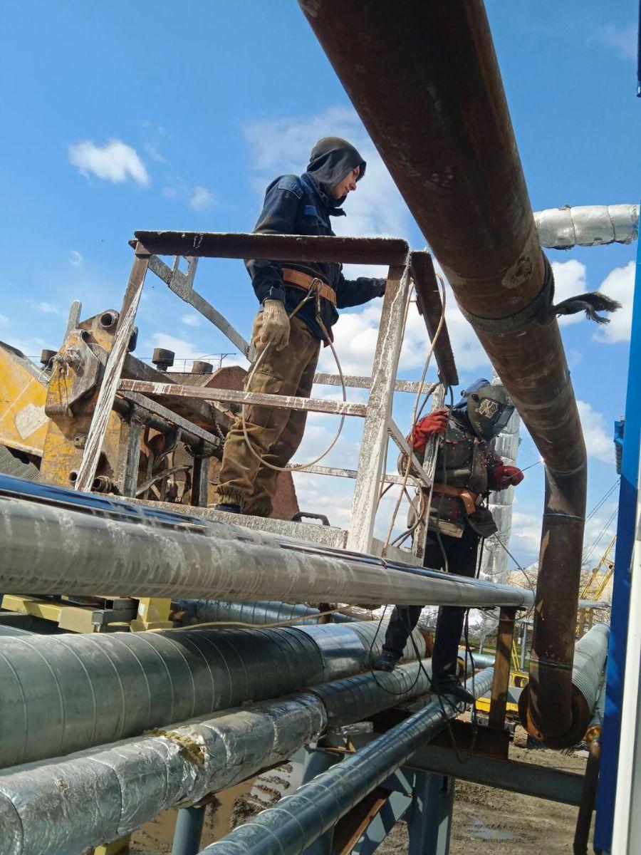 Skilled technicians mounting a steam pipeline for efficient plant operations
